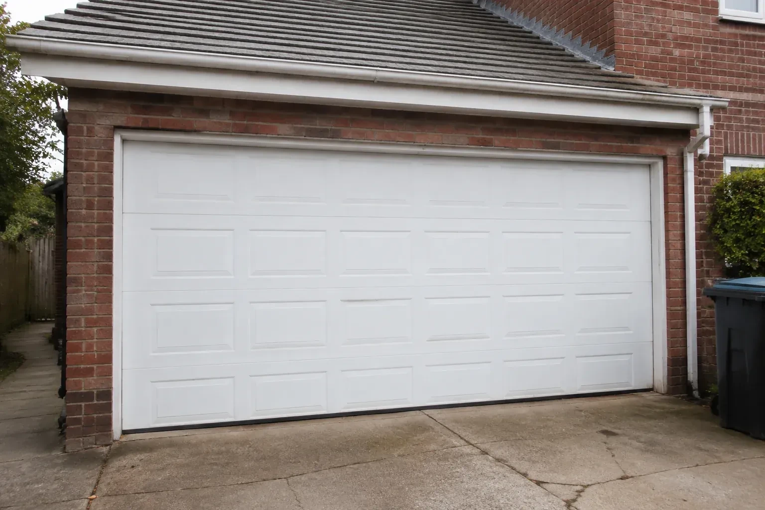 Closed white sectional garage door at an ordinary brick house. — Sectional Garage Door Replacement, Lincoln
